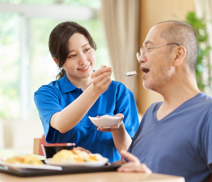 A caregiver who assists the elderly with meals