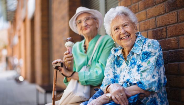 Portrait,Of,Two,Senior,Female,Friends,In,The,City,,Eating